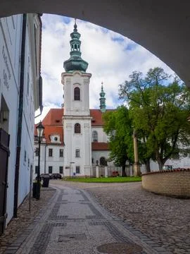 An arched passageway frames a view of the Strahov Monastery in Prague 库存照片