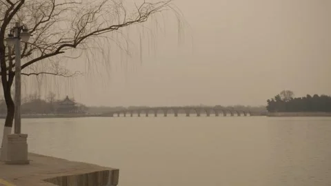 Arched Stone Bridge and Pavilion Reflected in Lake at Summer Palace, Beijing Stock Footage 345687179