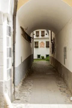 An arched stone tunnel frames a view of a white historic building with brown 写真素材