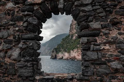 Arched stone window or opening in a stone wall overlooking scenic landscape.. Stock Photos