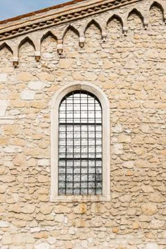 Arched window in the ancient stone wall Stock Photos
