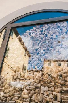 Arched window filled with wine corks and sky reflection Foto stock