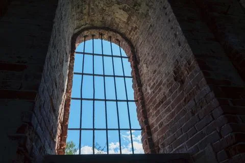Arched window with iron bars in old brick wall Stock Photos