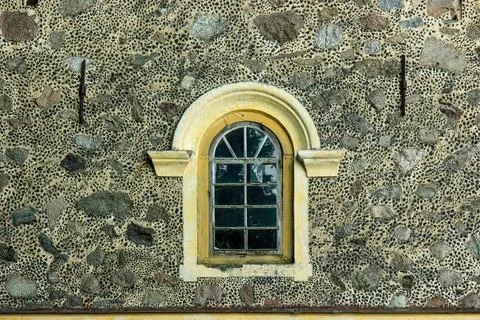Arched window set in historic stone mosaic facade Foto stock