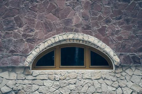 Arched window on a stone wall, close-up, with space to copy. The wall of the Stock Photos