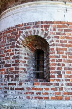 Arched window in the wall of the monastery. Stock Photos
