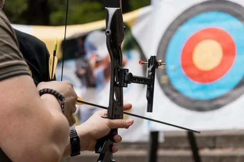 Archer Aiming Compound Bow at Target: Outdoor Archery Sport with Blue Targe.. Stock Photos