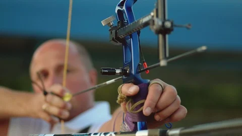Archer firing an arrow from his compound bow toward a range target Stock Footage 116025075