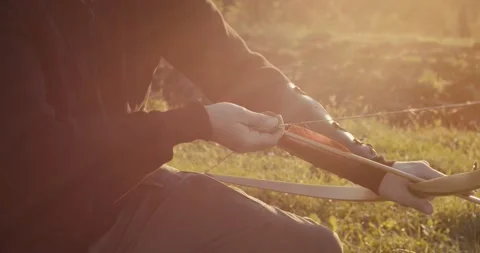 Archer man draw or pull a bow and aim shoot or release arrow close up Stock Footage 147396841