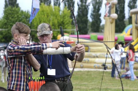 Archer teaching a boy of archery Stock Photos