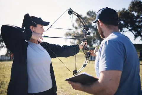 Archery, bow and arrow with woman and coach, aim at target with sports outdoor Stock Photos