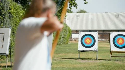 Archery player aiming at target practicing precision and focus Stock Photos