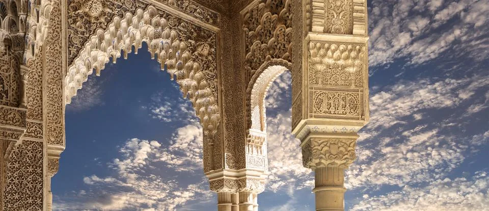 Arches in Islamic style (against the evening sky) in Alhambra, Granada, Spain Stock Photos