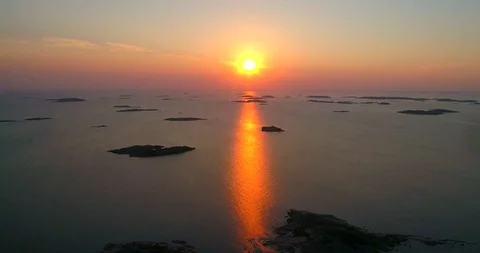 Archipelago sunset, C4K aerial sideway view of sunset reflecting between finn Stock Footage 95690884
