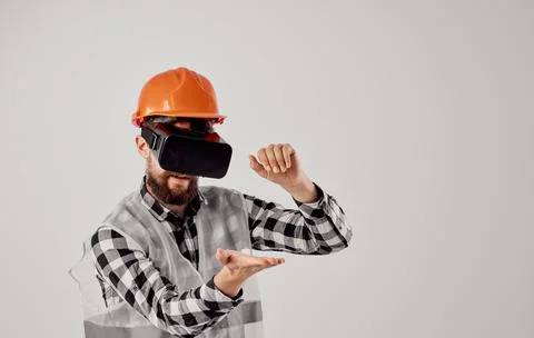 An architect in 3D virtual reality glasses gestures with his hands and an orange Stock Photos