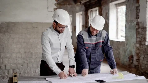 Architect and construction engineer are discussing plan and blueprint on the Video stock 77733901