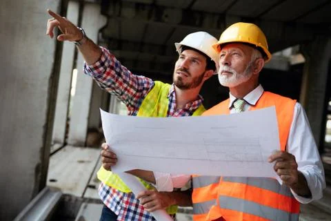 Architect and construction engineer or surveyor discussion plans and blueprints Фото