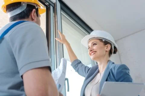 Architect and construction worker checking windows on site Stock Photos