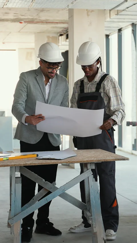 Architect and construction worker discussing blueprint on construction site Stock Footage 312845239