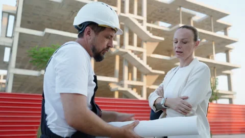 Architect and construction worker discussing building documentation during .. Stock Footage 341334148