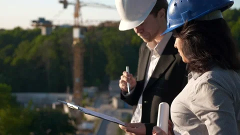 Architect and Engineer on Construction Site with Cranes. Male Female Colleagues Video stock 137299262