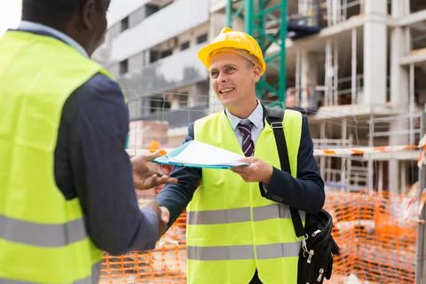 Architect and engineer construction workers shaking hands while working for Foto stock