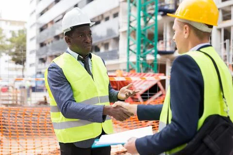 Architect and engineer construction workers shaking hands while working for Foto stock