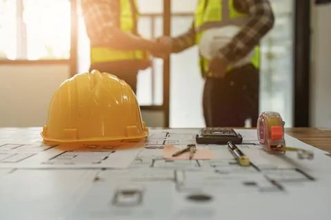 Architect and engineer construction workers shaking hands after finish an Foto stock