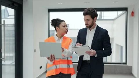 Architect and Engineer Discuss Building Plans in a Modern Office Stock-Footage 308055387