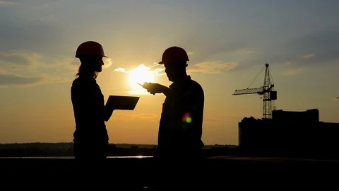 Architect and engineer discuss the project  at sunset . silhouettes Stock Footage 105283073