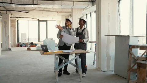 Architect and engineer discussing building plans in unfinished building Stock Footage 312829930