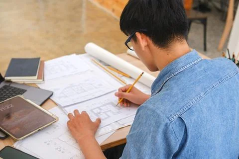 Architect and engineer drafting blueprints with a pencil and ruler at a wor.. Stock Photos