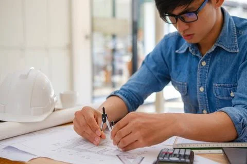Architect and engineer using a compass to design house plans at a work des... Stock Photos