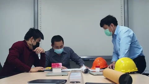 Architect and engineer wearing protective masks discussing in a meeting room. Stock Footage 153256442