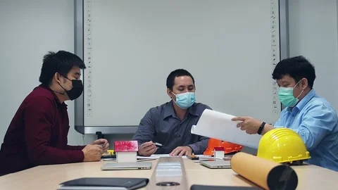 Architect and engineer wearing protective masks discussing in a meeting room. Stock Footage 155619037
