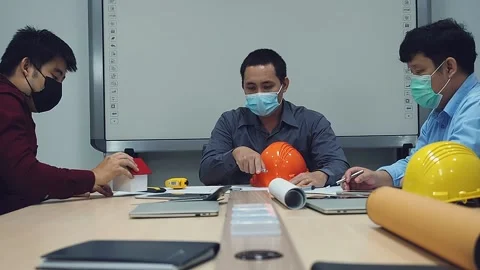 Architect and engineer wearing protective masks working together in a office. Stock Footage 163094076