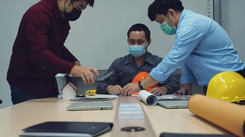 Architect and engineer wearing protective masks working together in a office. Stock Footage 163829640