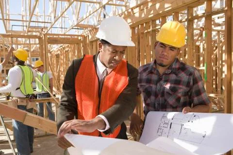 Architect And Foreman Having Discussion Over Blueprint Stock Photos