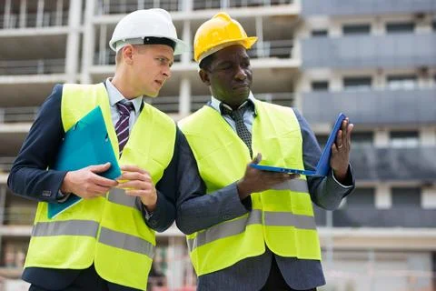 Architect and foreman must write documents and drawings on laptop with building Stock Photos
