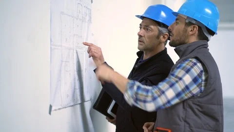 Architect and head builder looking at blueprint discussing construction plan Video stock 105344822