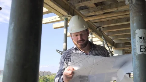 Architect browsing building project and comments it. Dolly shot backward. 库存影片 70804475