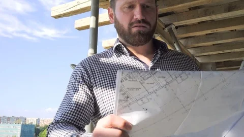 Architect browsing building project and comments it. Dolly shot forward. Vídeo Stock 70804543