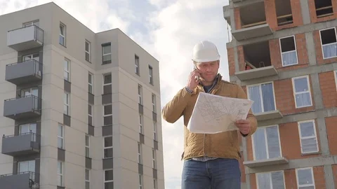 Architect browsing building project, talking by smartphone. Video stock 72357590