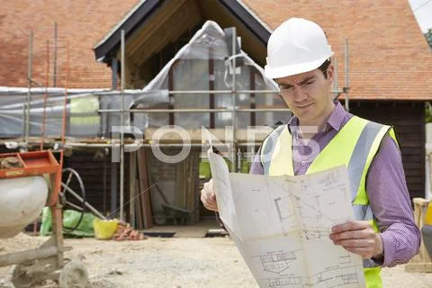Architect on building site looking at house plans Stock Photos