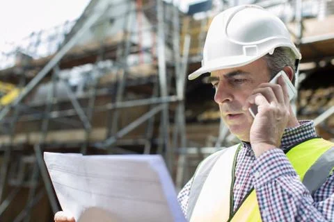Architect On Building Site Using Mobile Phone Stock Photos