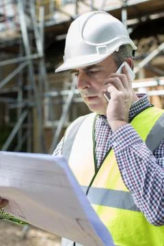 Architect On Building Site Using Mobile Phone Stock Photos
