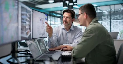Architect Carefully Studies 3D Building Model On Laptop For Project Planning. Foto stock