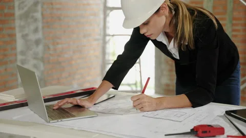 Architect checking blueprints inside a building at a construction site Stock Footage 232282881