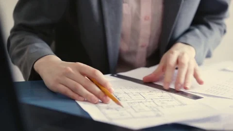 Architect checking numbers on blueprint during house construction planing Stock Footage 72777124