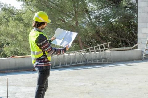 Architect checking the plan of a house under construction Stock Photos
